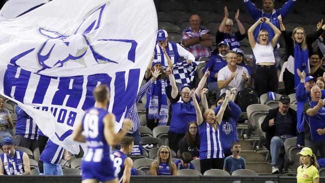 MELBOURNE, AUSTRALIA - MARCH 21: North Melbourne fans celebrate a goal during the AFL Round 01 match between the North Melbourne Kangaroos and the Port Adelaide Power at Marvel Stadium on March 21, 2021 in Melbourne, Australia. (Photo by Dylan Burns/AFL Photos via Getty Images)