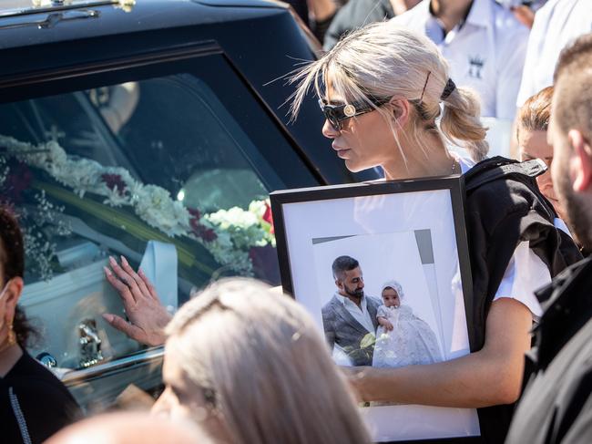 A woman carrying Kettule’s photo touches the hearse. All pictures: Julian Andrews