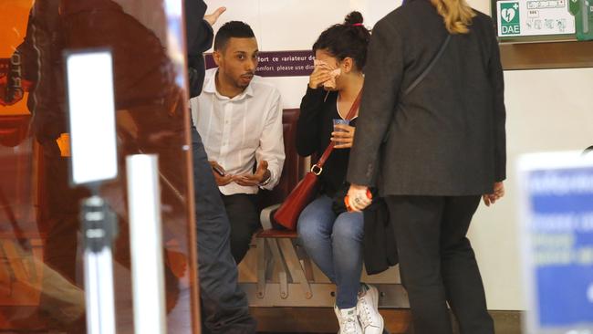 A relative wipes her tears as she is comforted at Charles de Gaulle Airport in Paris.