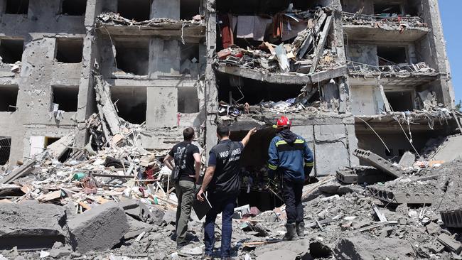 A war crimes prosecutor inspects where 18 civilians were killed a building destoyed by a Russia strike in Sergiyvka. Picture: AFP