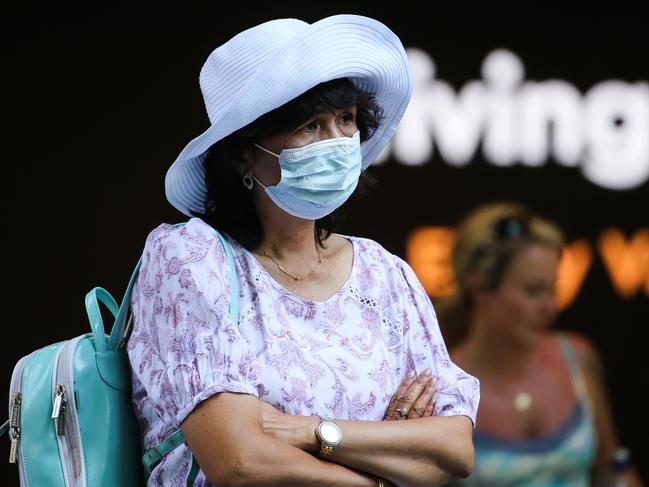 SYDNEY, AUSTRALIA - Newswire Photos JANUARY 03, 2022: A woman is seen wearing a face mask as she stops to watch the performer entertain the crowds shopping in Pitt Street Mall in the CBD in Sydney as Covid continues with very few people seen wearing face masks. Picture: NCA Newswire / Gaye Gerard