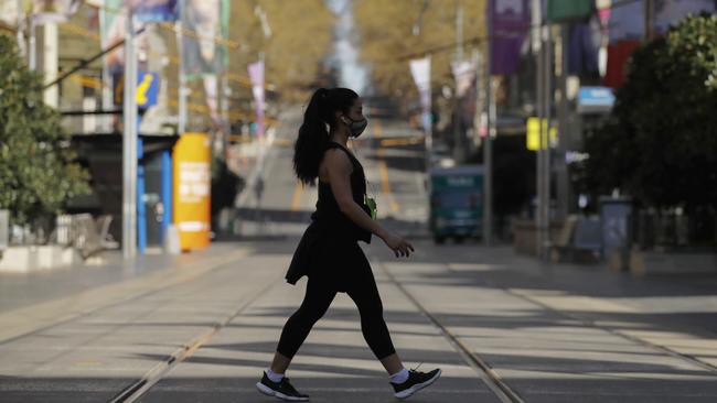 A woman crosses a deserted CBD street. Picture: NCA NewsWire/Daniel Pockett