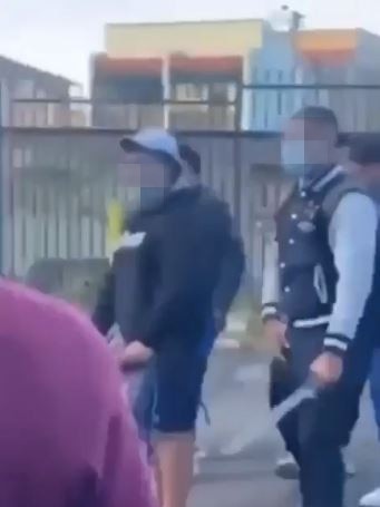 School children pulling knives from their school bags and pockets including a machete.