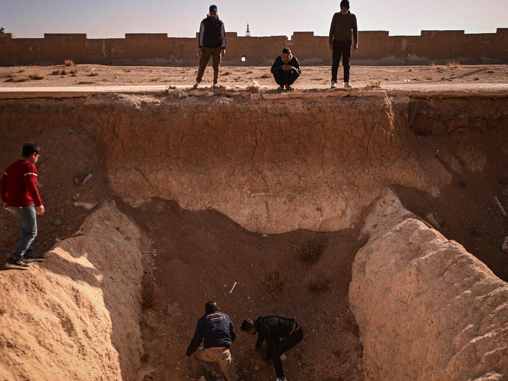 People search for human remains at a trench believed to be used as a mass grave on the outskirts of Damascus on December 16. Picture: Aris Messinis/AFP