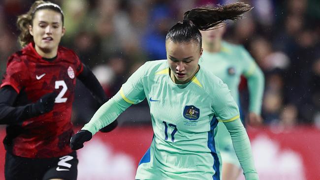 LANGFORD, BRITISH COLUMBIA - DECEMBER 01: Cloe Lacasse #20 and Sydney Collins #2 of Canada look on as Amy Sayer #17 of Australia plays the ball during the first half of their friendly match at Starlight Stadium on December 01, 2023 in Langford, British Columbia. (Photo by Jeff Vinnick/Getty Images for Football Australia)