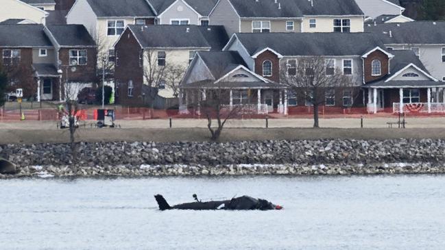 Part of the wreckage is seen along the Potomac River after American Airlines flight 5342 on approach to Reagan National Airport crashed into the river after colliding with a US Army helicopter, near Washington, DC, on January 30, 2025. US President Donald Trump -- speaking as the bodies of 67 people were being pulled from Washington's Potomac River -- launched a political attack January 30, 2025 blaming diversity hires for the midair collision between an airliner and a military helicopter. (Photo by Oliver Contreras / AFP)