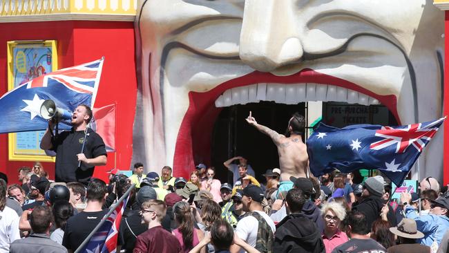 A protester addresses the crowds outside Luna Park in St Kilda. Picture: AAP