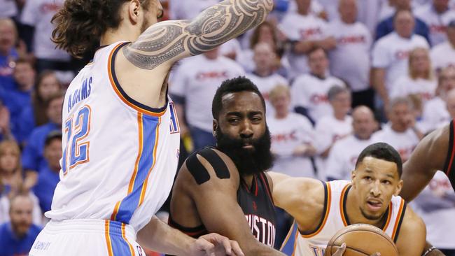 Houston Rockets guard James Harden, center, drives between Oklahoma City Thunder center Steven Adams (12) and forward Andre Roberson, right, in the first quarter of a first-round NBA basketball playoff game in Oklahoma City, Friday, April 21, 2017. (AP Photo/Sue Ogrocki)