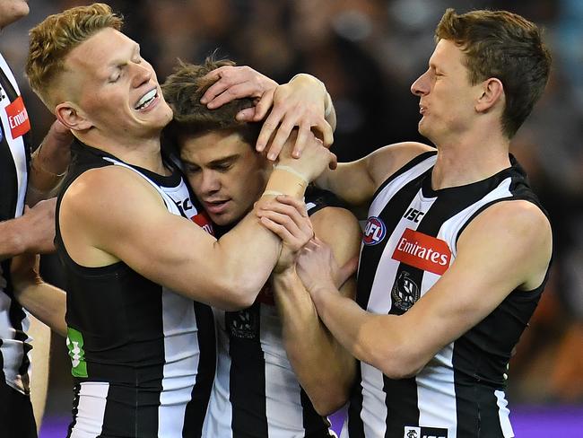 Adam Treloar and Will Hoskin-Elliott get around Thomas after he booted a goal against GWS in the semi-final win. Pic: AAP