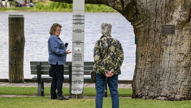 Tourists look at a flood marker at Mannum on the Murray River yesterday. Picture: Brenton Edwards