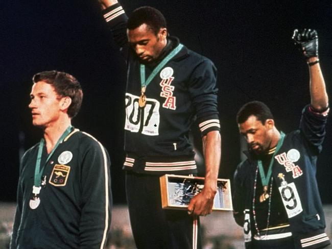 In this 16 Oct 1968 file photo, extending gloved hands skyward, USA athletes Tommie Smith, centre, and John Carlos, right, stare downward during the playing of the "Star-Spangled Banner" after Smith received the gold and Carlos the bronze for the 200 metre run at the Summer Olympic Games in Mexico City. Smith and Carlos are in Mexico City to celebrate the 40th anniversary of their famous Black Power salute. Australia's silver medallist Peter Norman is at left.