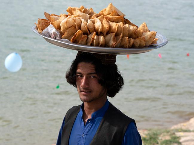 An Afghan snack vendor selling 'sambusa', fried dough stuffed with potatoes, looks for customers along the shore of Qargha Lake on the outskirts of Kabul. Picture: AFP