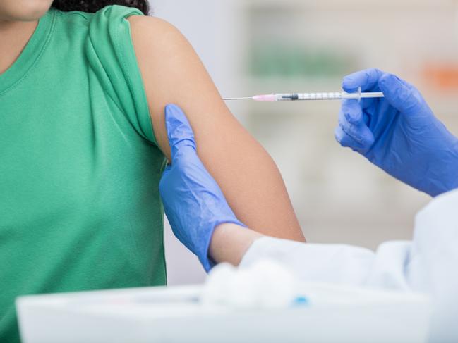 Healthcare professional gives girl a flu vaccine.