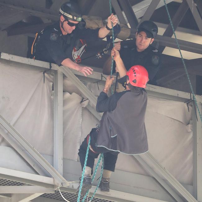 Police retrieve an Extinction Rebellion protester from the Story Bridge. Picture: Peter Wallis