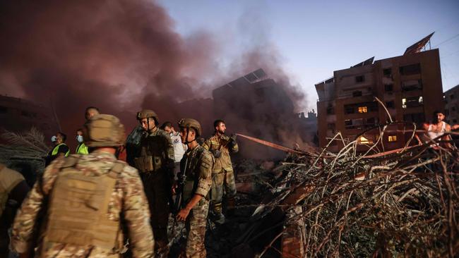 Lebanese army soldiers and people gather at the scene of Israeli air strikes in the Haret Hreik neighbourhood of Beirut's southern suburbs. Picture: AFP