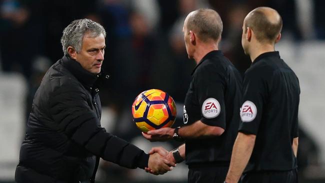 Manchester United's Portuguese manager Jose Mourinho (L) shakes hands with referee Mike Dean.