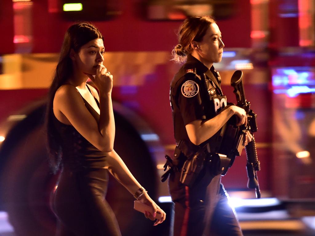 A police officer escorts a civilian away from the scene of a shooting, Sunday, July 22, 2018, in Toronto. Picture: AP