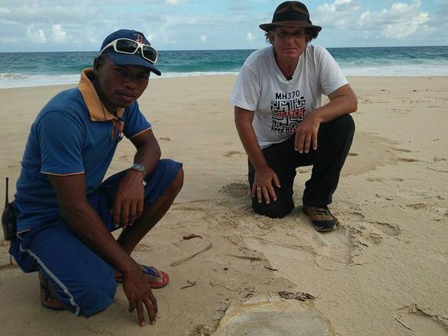 Blaine Alan Gibson and helper Cyriak, with the latest piece of possible MH370 debris found on Riake Beach, Madagascar. Picture: Facebook