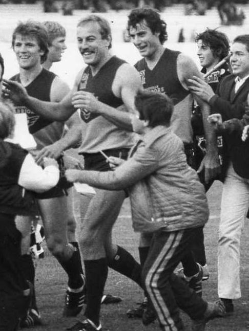 Captain-coach Malcolm Blight leads the Woodville players from the field after a surprise victory in 1983.