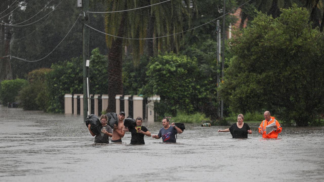 Local residents wade through floodwaters with their belongings in Sydney. Picture: Reuters