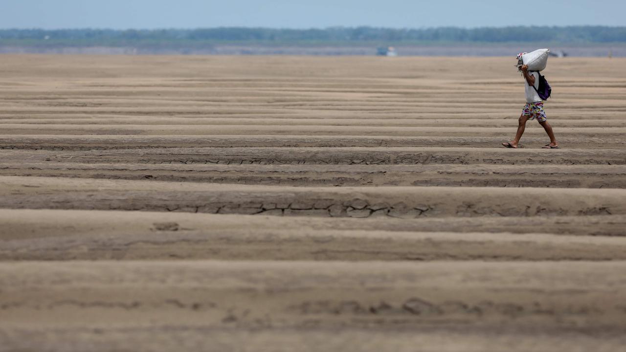 A river dweller walks on the dry bed of the Solimoes River, in the Pesqueiro Community, in Manacapuru, Amazonas state, northern Brazil, on September 30, 2024. More than 420,000 children in the Amazon Basin are being badly affected by a drought parching much of South America that is impacting water supplies and river transport, UNICEF said on November 6. Picture: AFP