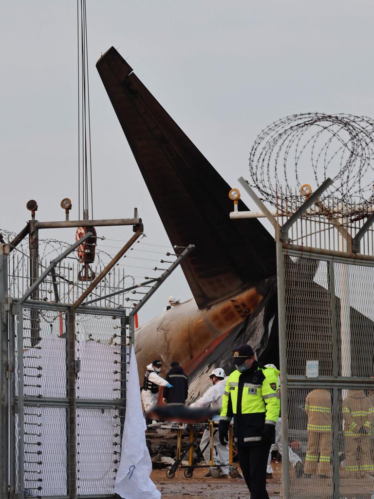 A police officer stands guard near the scene where a Jeju Air Boeing 737-800 series aircraft crashed and burst into flames at Muan International Airport. Picture: AFP