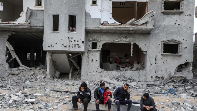 People sit by their destroyed homes in Rafah, Gaza. Picture: Getty Images