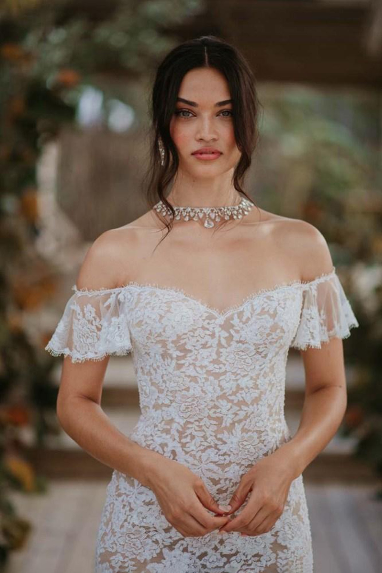 <p><em>Image credit: courtesy of Shanina Shaik. From <a href="https://www.vogue.com.au/brides/trends/inside-australian-model-shanina-shaiks-caribbean-islands-wedding/image-gallery/01dc6074d5e73a531f6a75c748df771c" target="_blank" rel="noopener">inside Australian model Shanina Shaik's Caribbean island wedding</a></em></p><h2>Shanina Shaik in Ralph and Russo</h2><p>In April 2018, Australian model Shanina Shaik married musician Gregory Andrews in a beachside wedding in the Bahamas. Shaik wore a Boho-inspired Ralph and Russo gown, with intricate lace detailing and soft flared capped sleeves that elegantly dropped off her shoulder. Her dainty and ethereal gown suited the warm backdrop of the water where the couple said their vows. She paired the gown with Aquazzura shoes and accessorised with Lorraine Schwartz jewels, most notably a pink and white diamond wreath necklace and matching earrings. Shaik later changed into a custom-made Michael Costello party look to dance the evening away.</p>