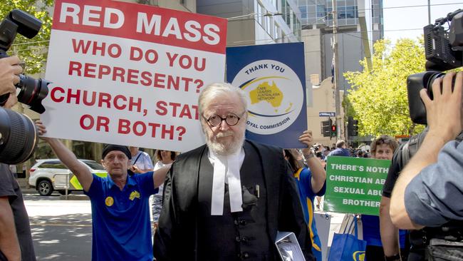 Cardinal George Pell's lawyer Robert Richter QC leaves the County Court surrounded by protesters. Picture: AP Photo/Andy Brownbill