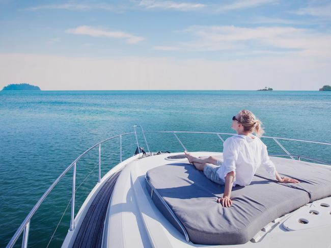 beautiful woman enjoying luxurious yacht cruise, sea travel by luxury boat; rich lifestyle wealth generic