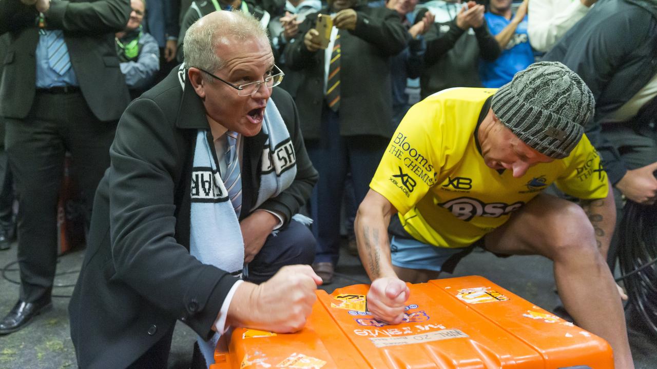 Prime Minister Scott Morrison bashes the Esky during the team song, but hurt himself in the process. (AAP Image/Craig Golding)