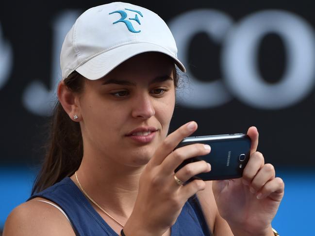 A spectator uses a mobile phone during the men's singles match between Italy's Andreas Seppi and Australia's Nick Kyrgios on day seven of the 2015 Australian Open tennis tournament in Melbourne on January 25, 2015. AFP PHOTO / PAUL CROCK -- IMAGE RESTRICTED TO EDITORIAL USE - STRICTLY NO COMMERCIAL USE