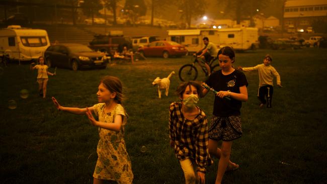 Abigail Ferris (in mask) plays with friends at a temporary evacuation centre in Bega on December 31, 2020. Picture: Sean Davey.