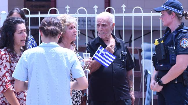 Members of the Greek community speak outside St Nicholas Church in Darwin. Picture: Amanda Parkinson