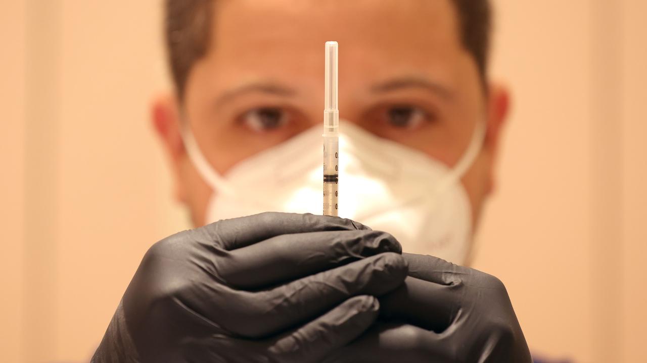 Jatniel Hernandez fills syringes with Covid-19 vaccine booster shots at a COVID-19 vaccination clinic. Picture: AFP.