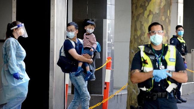 Quarantined international travellers board a coach outside the Holiday Inn in Melbourne. Picture: Andrew Henshaw