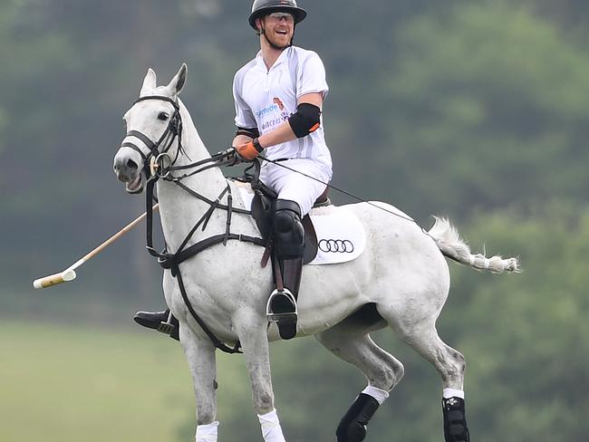 Prince Harry and his girlfriend exchange laughs while he plays polo. (Photo: James Whatling)