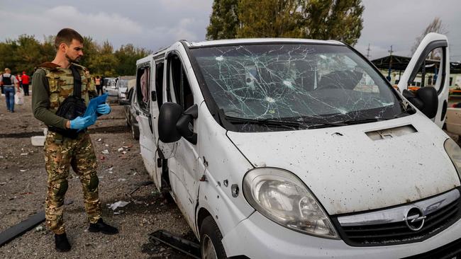 A Ukrainian serviceman checks a car damaged by a missile strike on a road near Zaporizhzhia. Picture: Kateryna Klochko / AFP