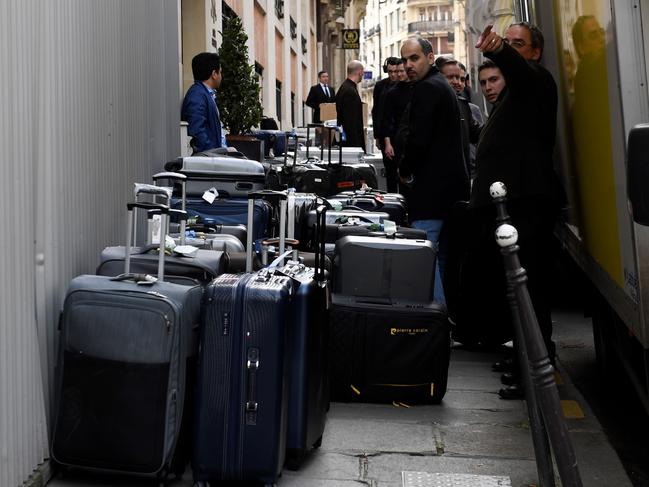 People unload luggage for Saudi Arabia's crown prince Prince Mohammed bin Salman's visiting delegation on April 4, 2018, near the Champs Elysee in Paris.  Saudi Arabia's crown prince Prince Mohammed bin Salman arrived in France on April 8, for the next leg of a global tour aimed at reshaping his kingdom's austere image as he pursues his drive to reform the conservative petrostate. / AFP PHOTO / Eric FEFERBERG