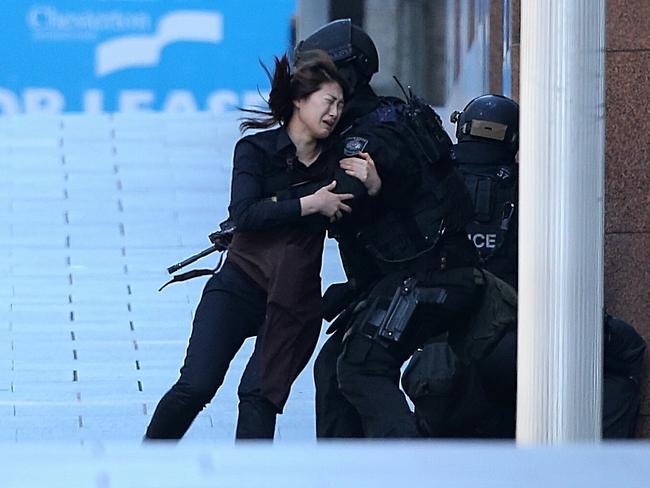 10. Another Lindt Cafe staff member Jieun Bae, 20, who had spent an hour unlocking a door latch to flee, is hauled to safety by a tactical operations unit officer. Picture: Adam Taylor