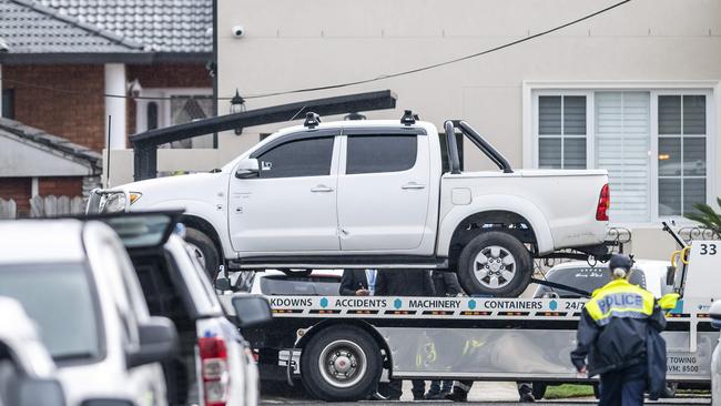 Ahmad’s white Toyota HiLux ute, littered with bullet holes, is taken from the scene for forensic examination by police. Picture: Darren Leigh Roberts