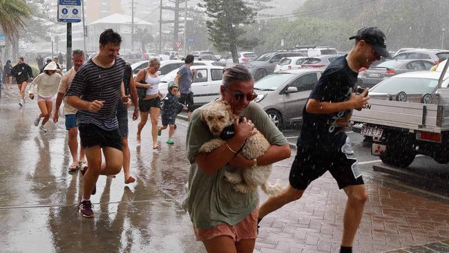 Members of the public run for shelter during a torrential downpour on the Gold Coast ahead of the expected arrival of Cyclone Alfred. Picture: NewsWire/Tertius Pickard