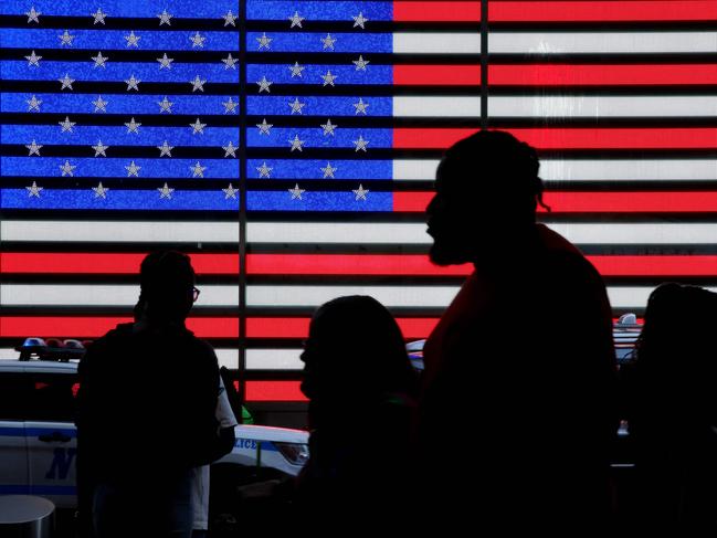 People walk by the electric American Flag of US Armed Forces Career Center in Times Square, New York City on June 16, 2023. (Photo by Leonardo Munoz / AFP)