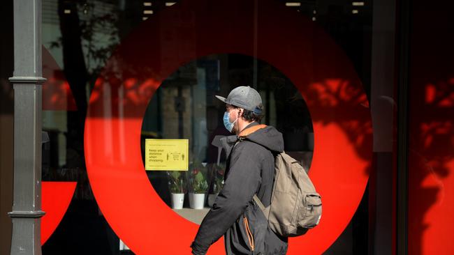 A person wearing a mask walks passed a Coles supermarket in Richmond. Picture: NCA NewsWire/Andrew Henshaw