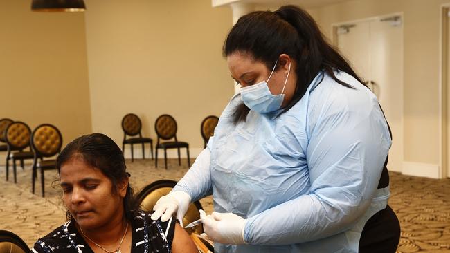 Komathy Nareshkumar receives a flu vaccination from nurse Nina Livingstone. Picture: John Appleyard