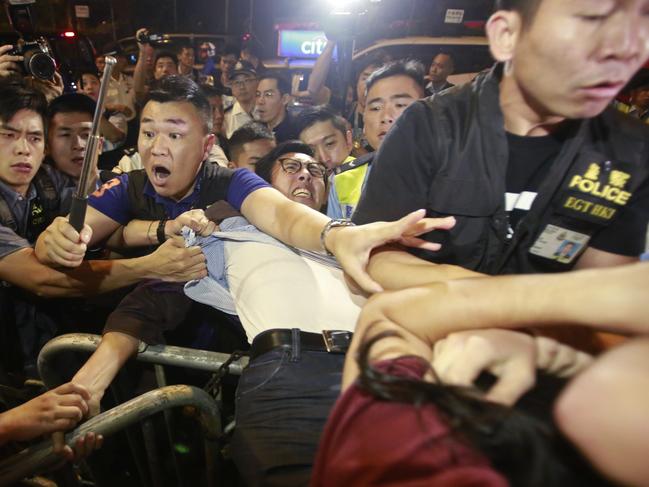 Protesters scuffle with police officers after clashing as thousands of people march in a Hong Kong street, Sunday, Nov. 6, 2016. Thousands of protesters marched in Hong Kong on Sunday, demanding that China's central government stay out of a political dispute in the southern Chinese city after Beijing indicated that it would intervene to deter pro-independence advocates. (AP Photo/Kin Cheung)