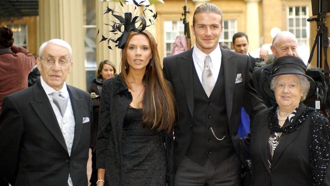 Posh and Becks, with his maternal grandparents, Joseph and Peggy West, after he received the Officer of the Order of the British Empire from The Queen at Buckingham Palace in 2003. Picture: AFP