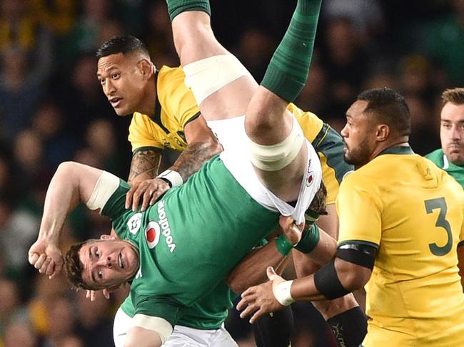 Ireland's Jack McGrath (C) and Australian Wallabies Israel Folau (top C) jump for the ball during the third and final rugby union Test match between Ireland and Australia in Sydney on June 23, 2018. / AFP PHOTO / PETER PARKS / --IMAGE RESTRICTED TO EDITORIAL USE - STRICTLY NO COMMERCIAL USE--