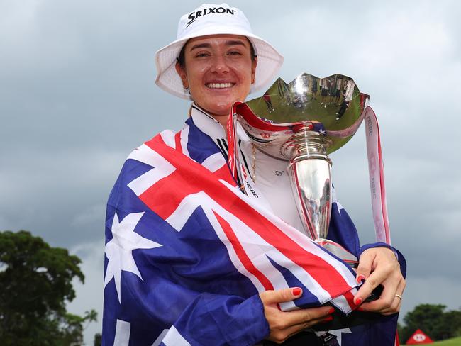 SINGAPORE, SINGAPORE - MARCH 03: Hannah Green of Australia poses with the trophy on the 18th green whilst wearing the Australian flag following victory on Day Four of the HSBC Women's World Championship at Sentosa Golf Club on March 03, 2024 in Singapore. (Photo by Andrew Redington/Getty Images)