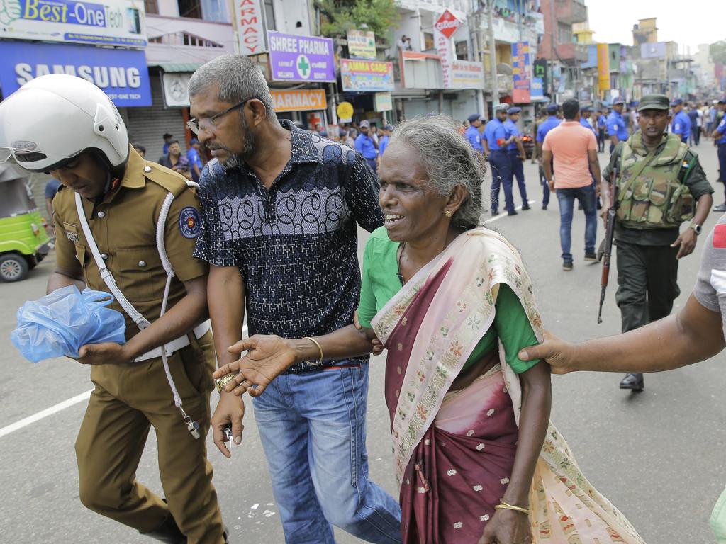 An elderly woman is helped near St. Anthony's Shrine after a blast in Colombo, Sri Lanka. Picture: AP